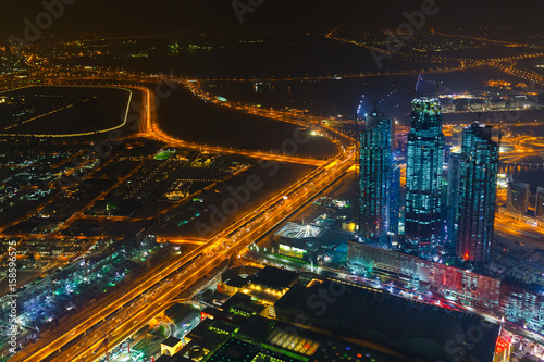 Panoramic aerial view on downtown of Dubai with modern high skyscrapers at night. Architecture of future with bright lights and roads. Famous tourist destination