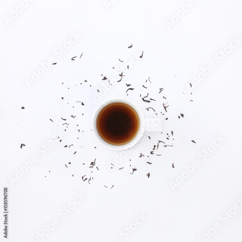 White cup with tea on a wooden round rack on a white background