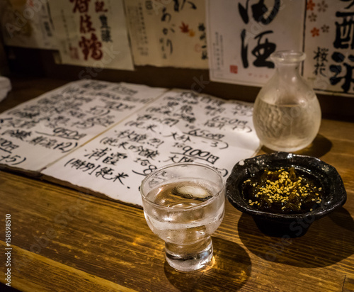 Traditional japanese sake and seaweed. Japanese menu and sake brands in the background.