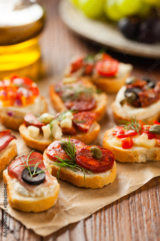 Crostini with different toppings on wooden background. Delicious appetizers. Front view.