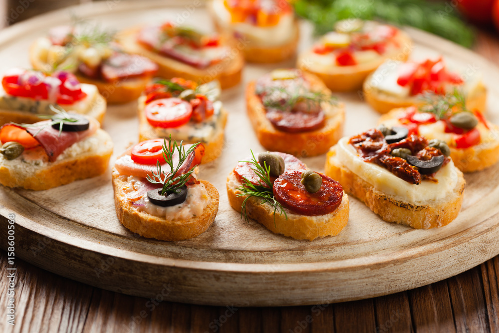 Crostini with different toppings on wooden background. Delicious appetizers. Front view.