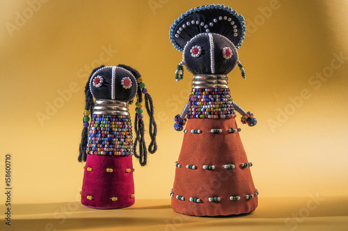 African cloth dolls isolated on yellow background photo