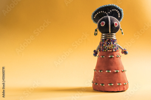 African cloth doll isolated on yellow background
