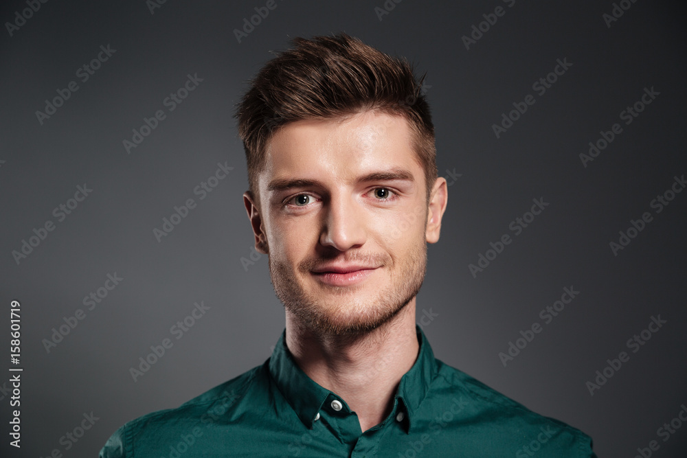 Fototapeta premium Cheerful young man posing isolated over grey background