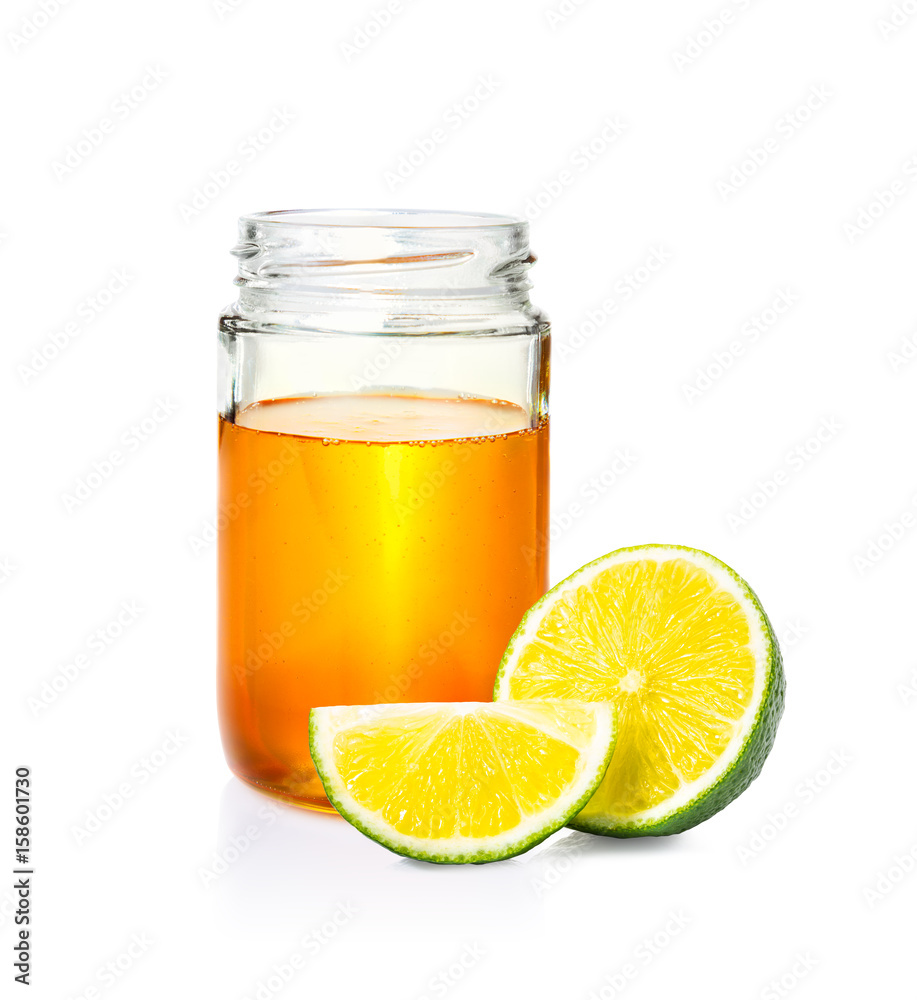 honey in glass jar and cut lime on white bacground honey in glass jar and cut lime on white bacground