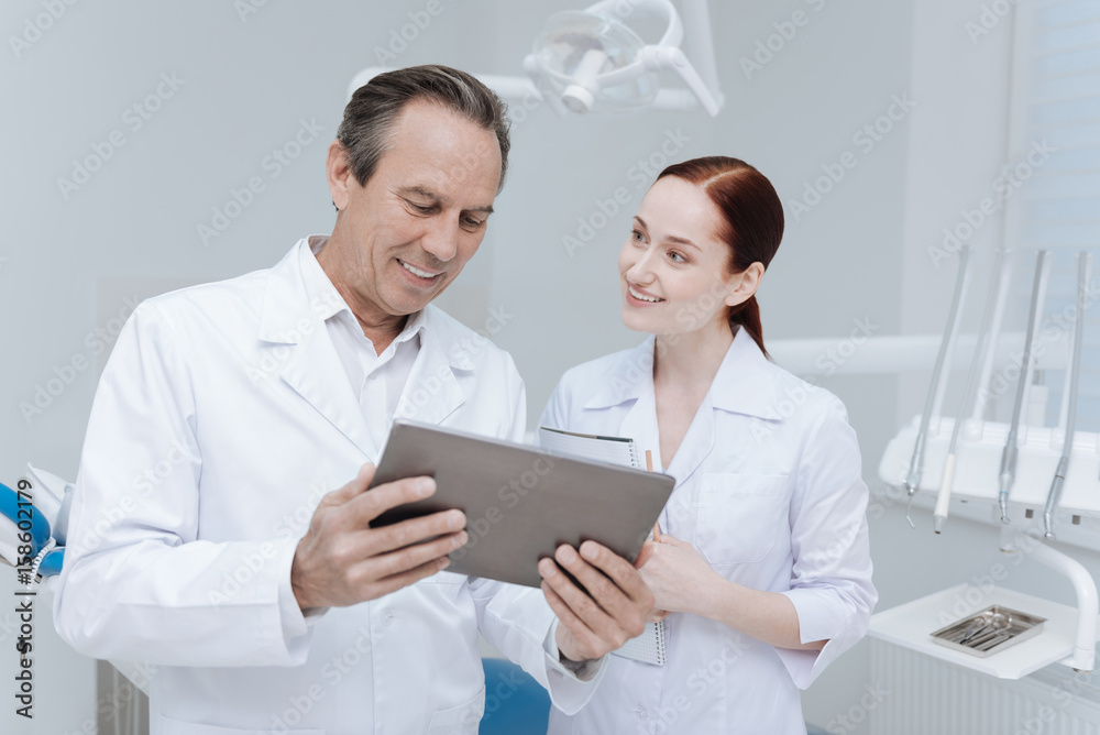 Young female assistant standing next to her mentor