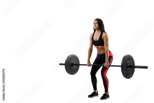 Young athletic woman doing deadlift with a barbell on a white isolated background, position of a semi-squat, legs at shoulder level