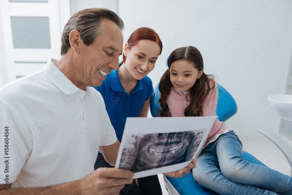 Delighted mother and daughter watching picture of the jaw Delighted mother and daughter watching picture of the jaw