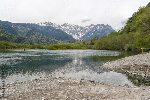 Hotaka mountain range and taisho ike pond in spring at kamikochi national park nagano japan photo