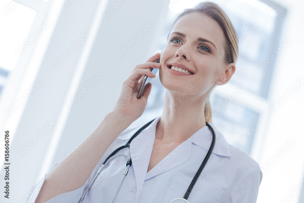 Friendly therapist using smartphone in the hospital Friendly therapist using smartphone in the hospital