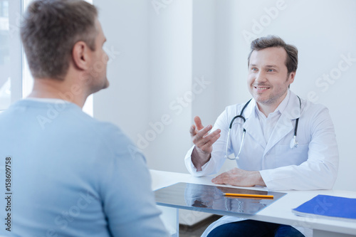 Pleasant doctor enjoying appointment in the clinic
