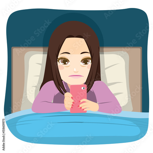 Young teenager girl using smartphone in bed addiction problem concept