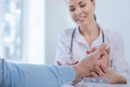 Professional medical specialist checking patient heart rate indoors