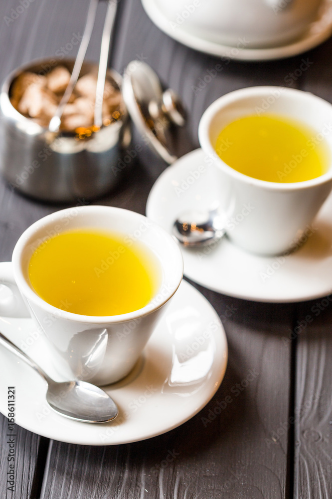 Two Cups of Green Tea and Brown Sugar on Dark Wooden Background, Vertical View