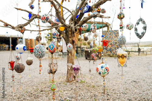colorful Arabian ornaments hanging on a dying tree with white background. The objects are commercial to be sold to customers from business owner. Buyer can use for any decoration in their home. 