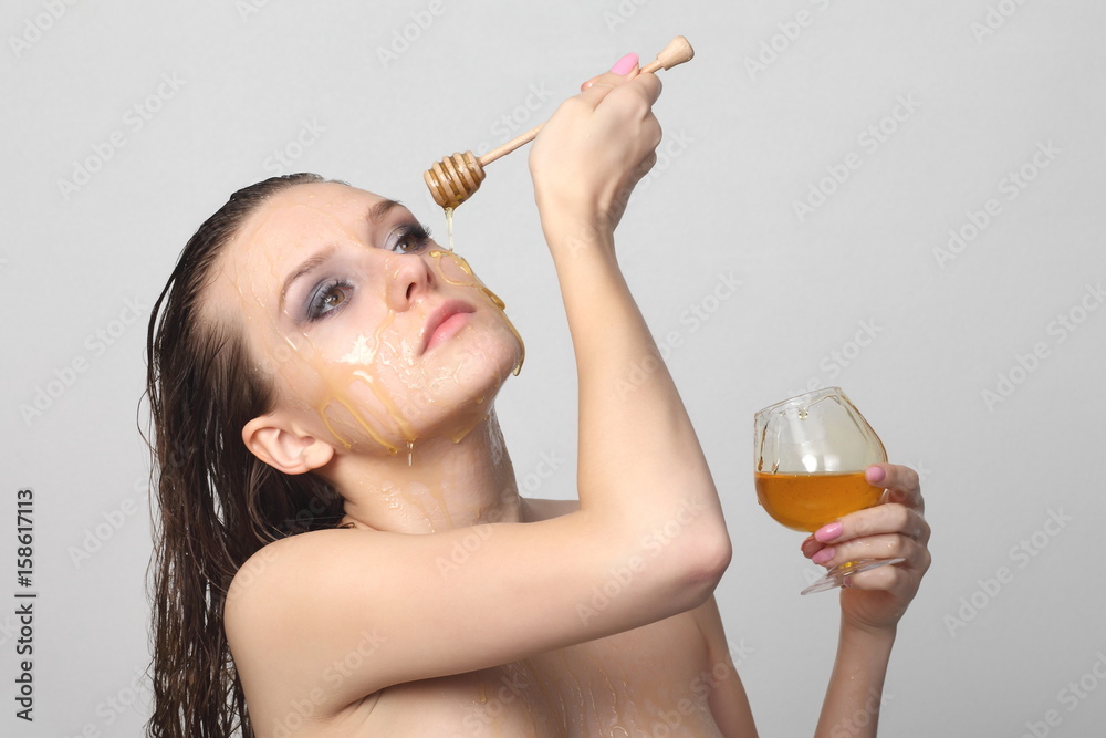 Fototapeta premium Beautiful woman with honey on her face