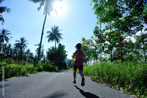 healthy lifestyle woman runner running on morning tropical forest trail