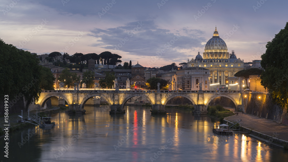 St. Peter's Basilica and Ponte Sant angelo at dusk in vatican city, Rome, Italy.