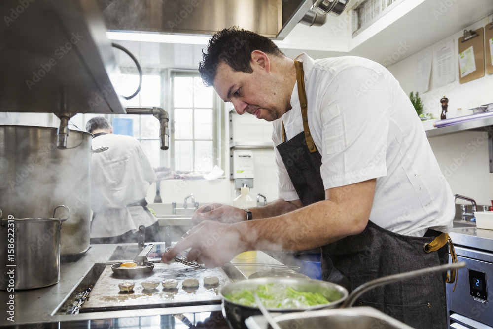 Chef cooking in the kitchen of a small boutique hotel. Chef cooking in the kitchen of a small boutique hotel.