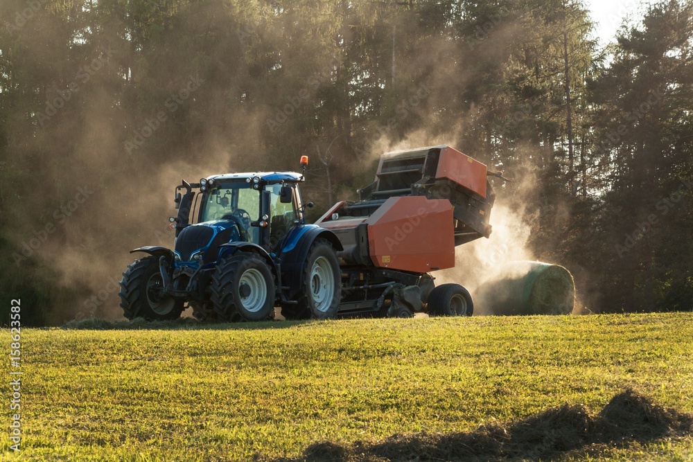 Fototapeta premium Blue tractor on the pasture.. Agricultural work on the farm in the Czech Republic.