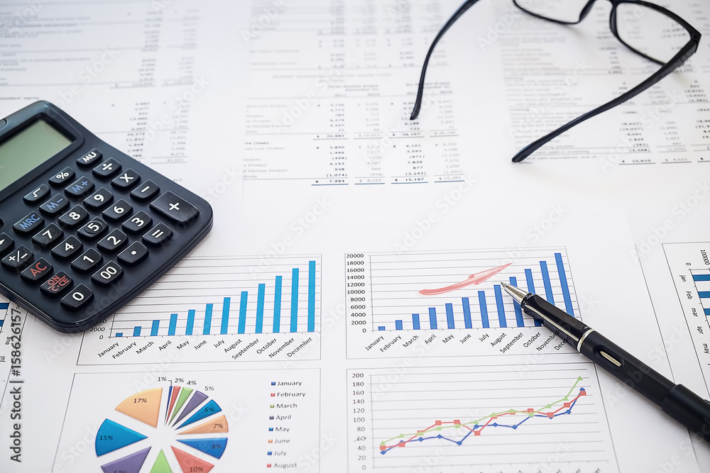 calculator and pen glasses and with Business report financial accounting graphs analysis calculator and pen glasses and with Business report financial accounting graphs analysis