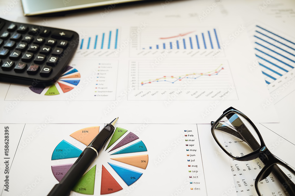 business concept : financial graph and chart report with pen, graph with notebook, glasses and calculator on desk of financial advisor. business concept : financial graph and chart report with pen, graph with notebook, glasses and calculator on desk of financial advisor.
