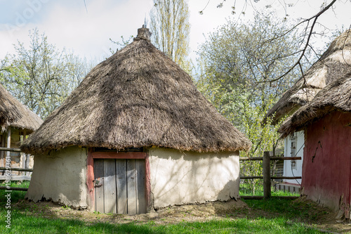 National Museum Pirogovo in the outdoors near Kiev. Ancient peasant Ukrainian house with a thatched roof, spring landscape in the old village of national architecture, Ukraine.