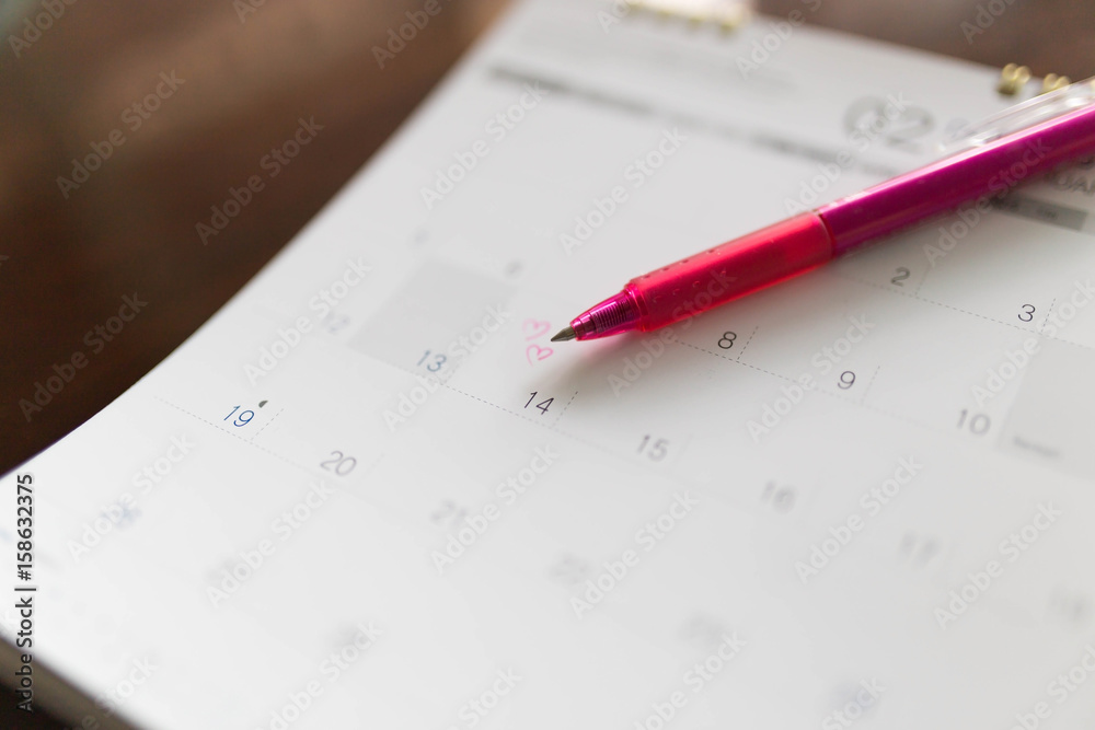 Blurred calendar opening on the page February. Focus the heart drawing on Feb 14 Blurred calendar opening on the page February. Focus the heart drawing on Feb 14