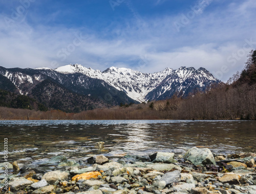 Beautiful landscape with river, tree, mountain cover by snow with blue sky background for people who love to rest, relax , travel or vacation