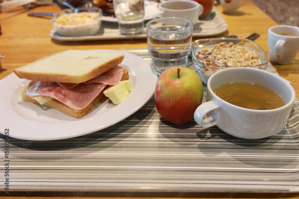A simple breakfast of apple, bread and ham.