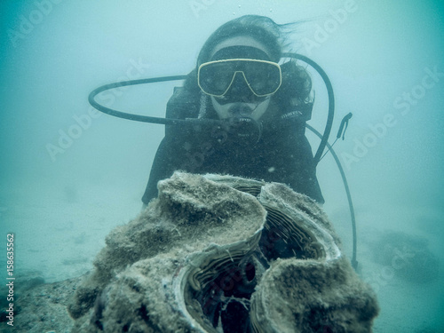 Woman scuba diver exploring underwater life in the deep blue ocean photo