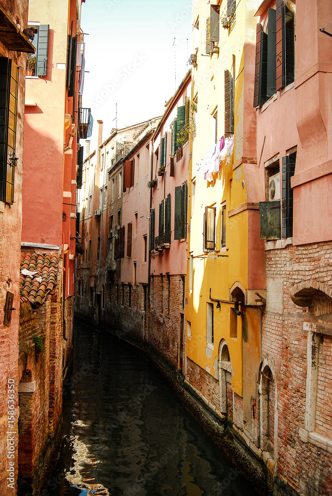 Old buildings line up a canal in Venice Italy on a warm spring day