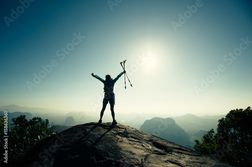 cheering successful woman hiker open arms on sunrise mountain top © lzf