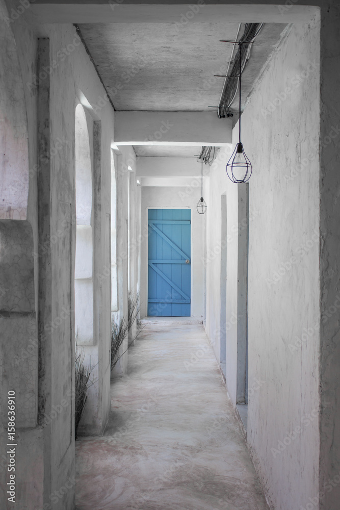 Hall way inside old building with blue door