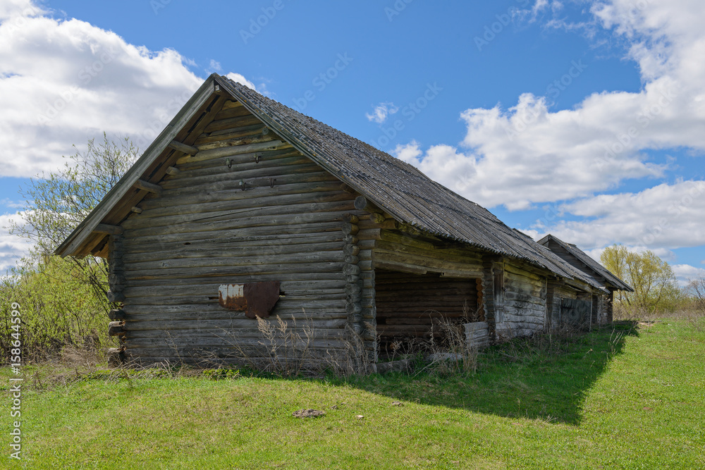 Old abandoned wooden house in a green spring field Old abandoned wooden house in a green spring field