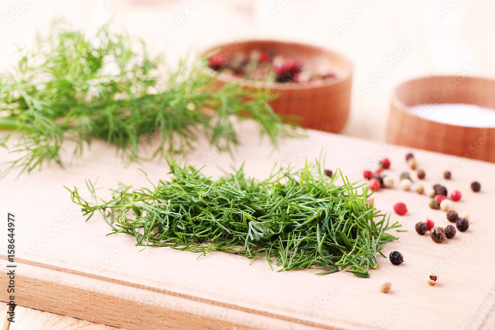 Green dill with pepper on brown cutting board Green dill with pepper on brown cutting board