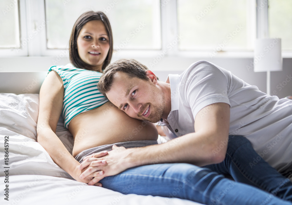 Young parents in bed expecting a little baby, Romantic moments for pregnant couple