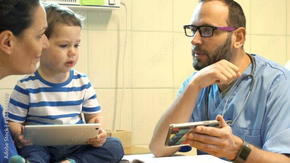 Doctor with smartphone talking to mother with child about test results in office Doctor with smartphone talking to mother with child about test results in office