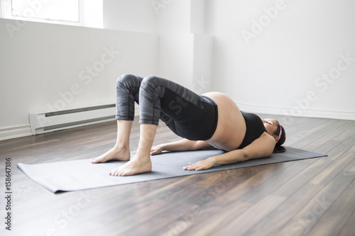 Pregnant woman doing stretching and yoga at home
