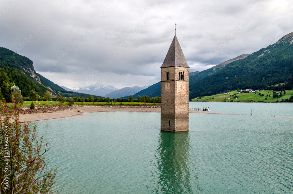 Old church tower flooded in the middle of Lake Nauders in Italy