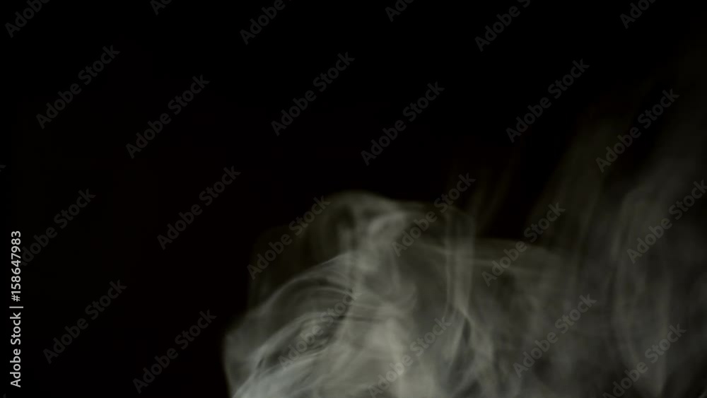 Slow motion , white cloud of cigarette smoke on black isolated background Slow motion , white cloud of cigarette smoke on black isolated background