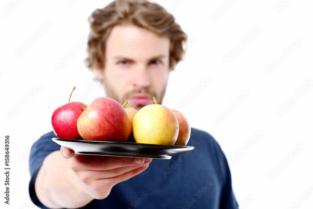 Face expression of strong and confident man offering apples Face expression of strong and confident man offering apples