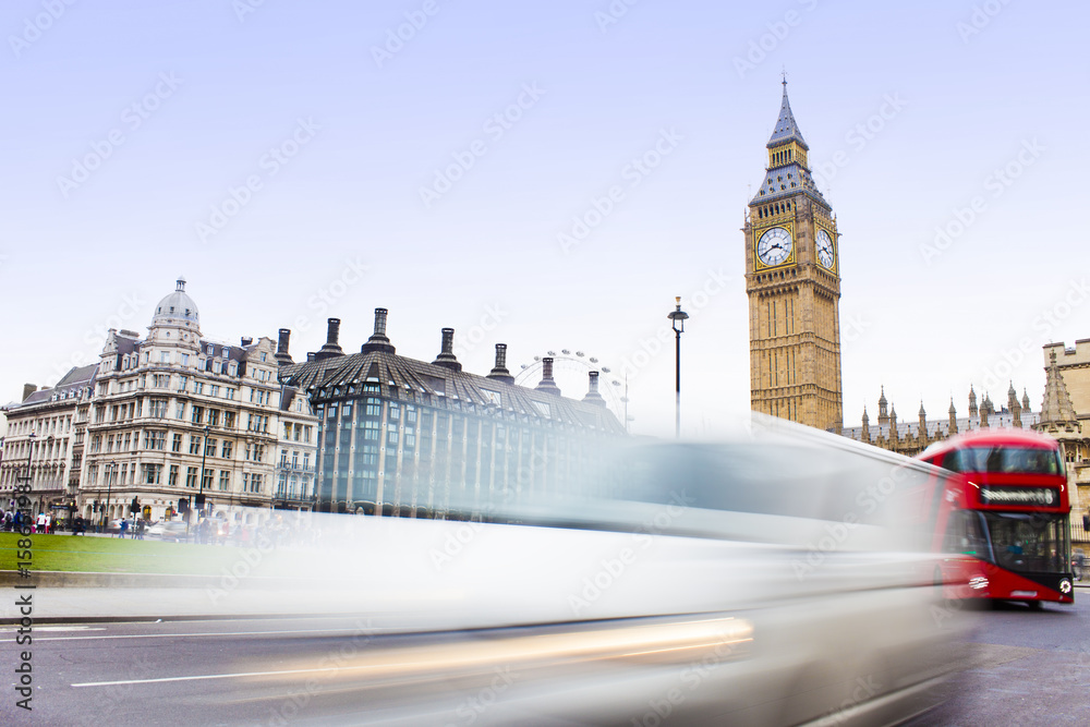 Traffic in Central London city, long exposure photo of red bus in intersection, Big Ben in background. long exposure photo