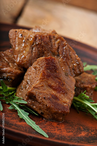 Freshly prepared juicy stewed veal adorned with leaves of arugula.