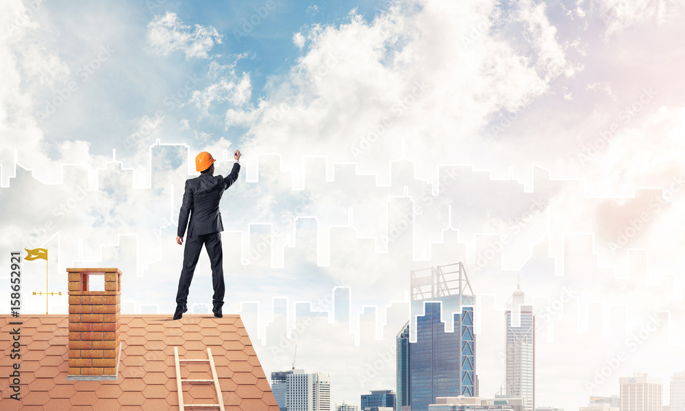 Man architect draw silhouette of modern city on blue sky. Mixed 