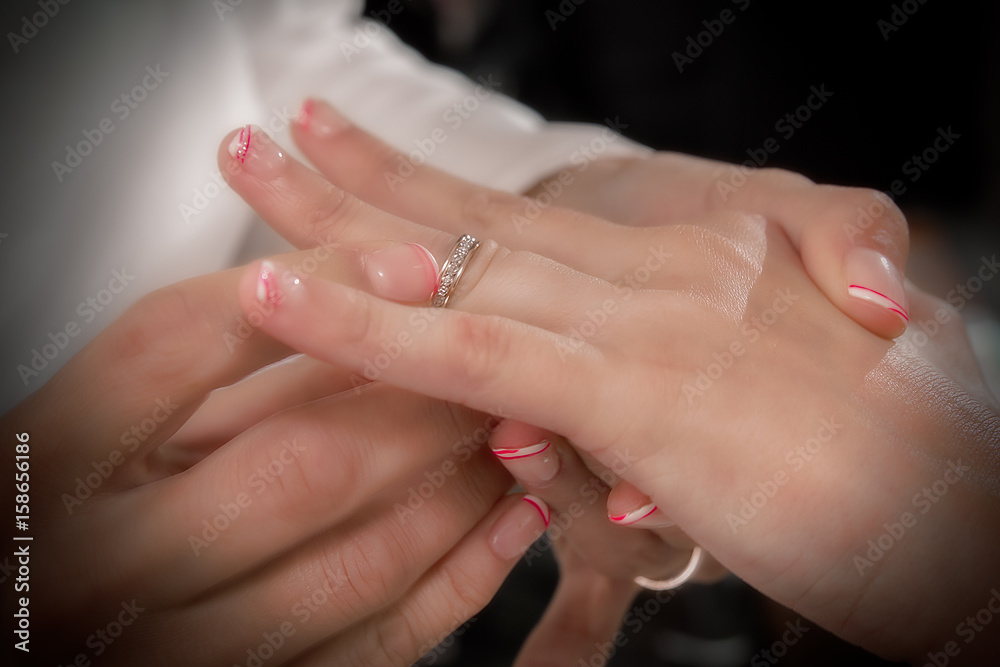 Close up hands of bride and groom putting on a wedding rings Close up hands of bride and groom putting on a wedding rings