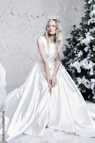 snow queen in white dress in ice room