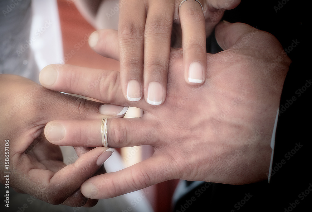 Close up hands of bride and groom putting on a wedding rings Close up hands of bride and groom putting on a wedding rings