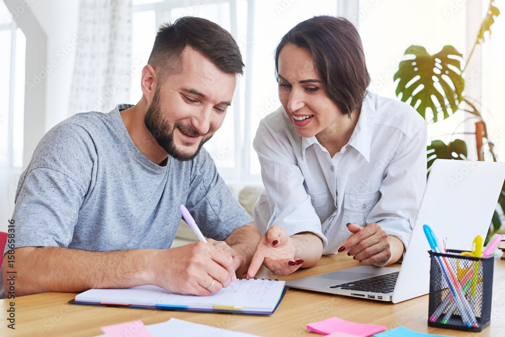Gorgeous lady telling something while man writing in notebook Gorgeous lady telling something while man writing in notebook