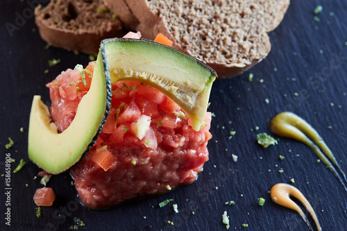 beef tartar with avocado and tomatoes photo